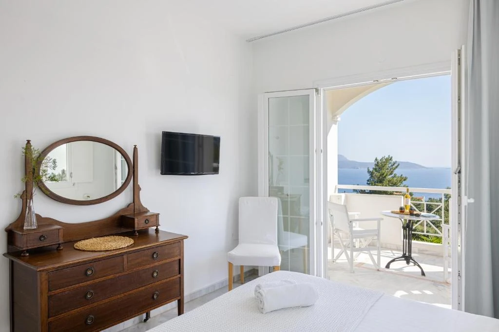 Υπνοδωμάτιο με ξύλινη τουαλέτα, καθρέφτη και πρόσβαση στο μπαλκόνι.