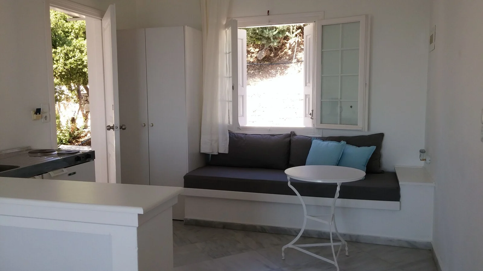 Studio sitting area with a dark sofa and white table.