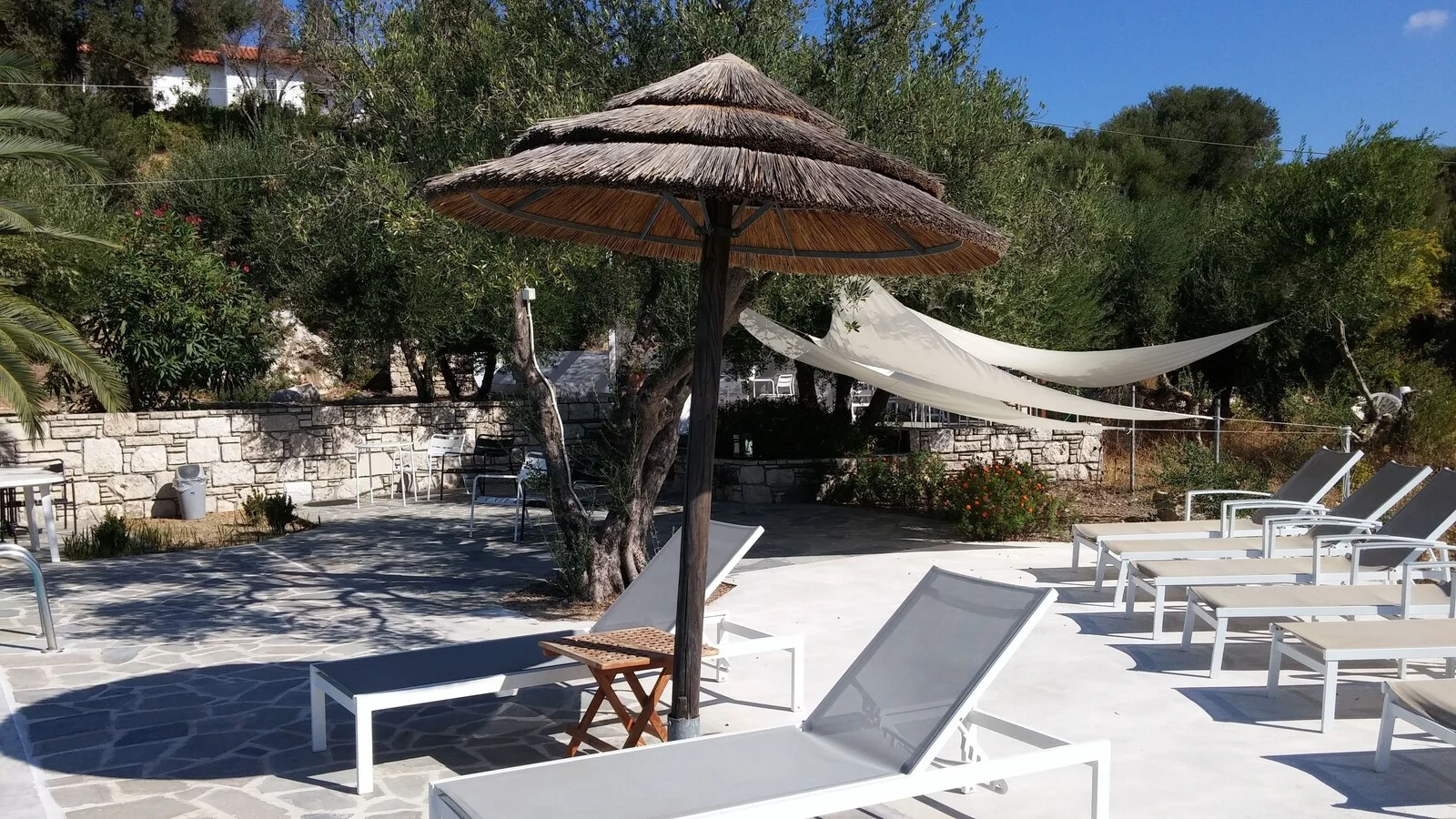 Sun loungers, a thatched parasol and a hammock on the terrace.