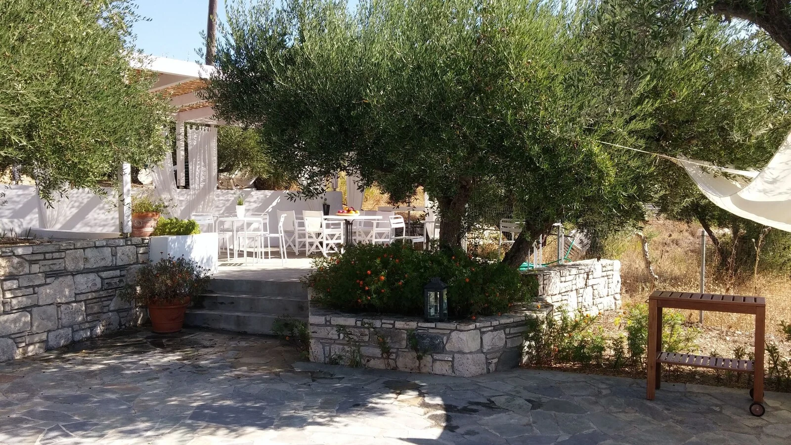 Stone garden walls and shaded outdoor seating.